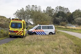 Wielrenner ziet gewonde fietser langs voetpad zitten